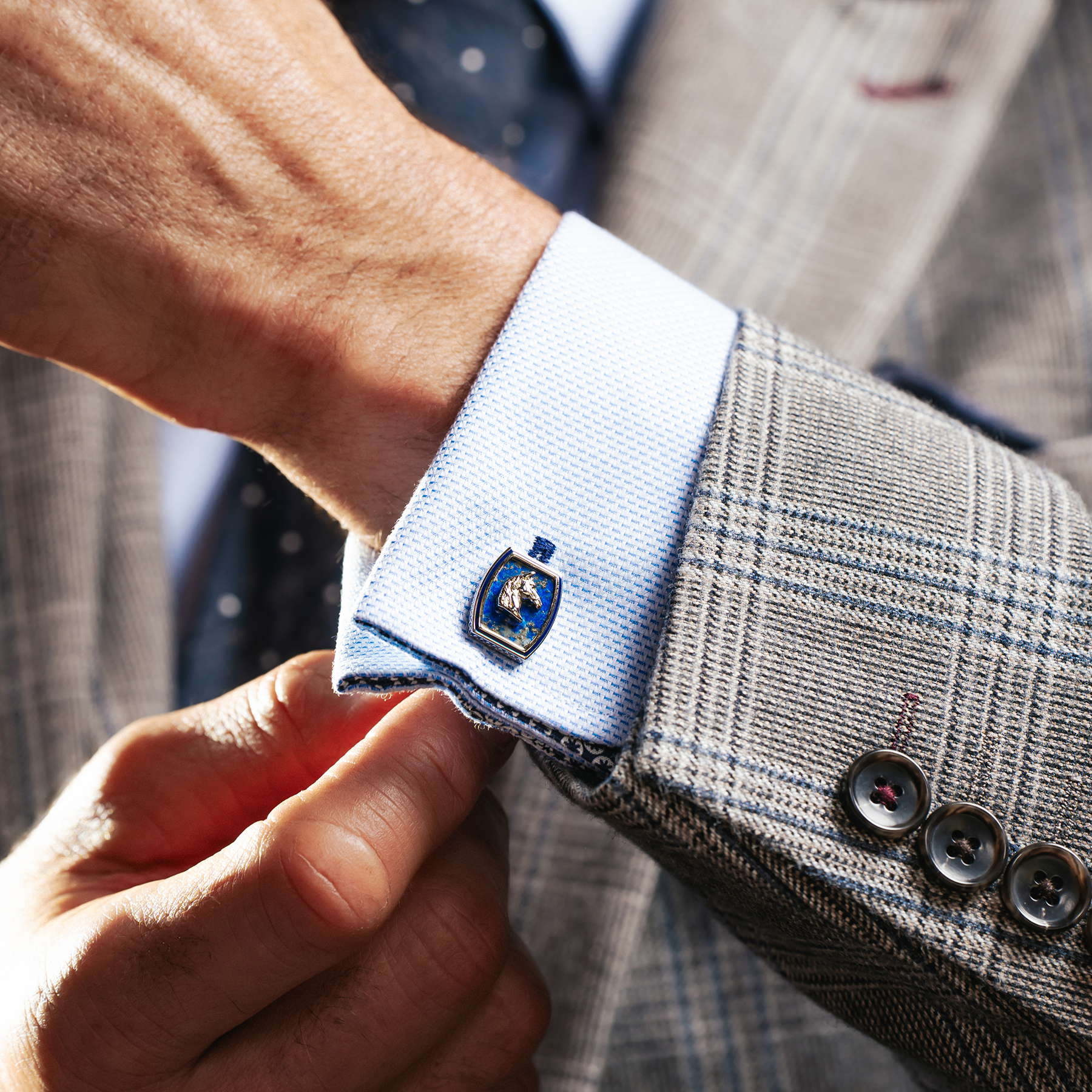 A pair of palladium plated cufflinks featuring an Ascot-inspired horse design with a blue lapis background and navy hand-painted enamel border.