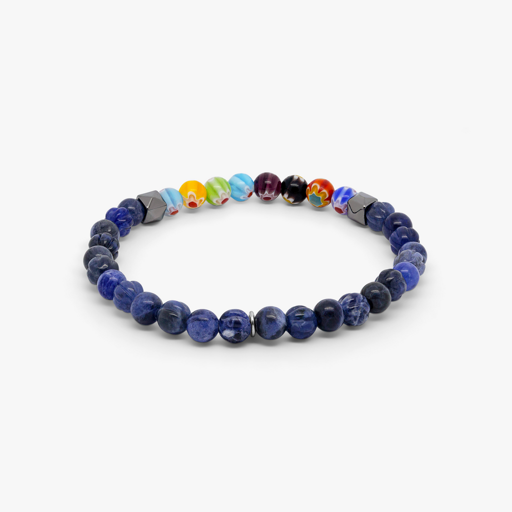 A multicolored beaded bracelet with blue sodalite and millefiori design, strung on an elastic band.