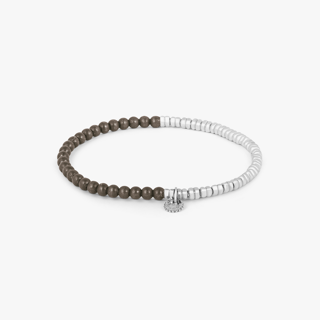 A bracelet with a combination of silver and grey titanium beads, featuring a half moon shape and a Tateossian gear tag.