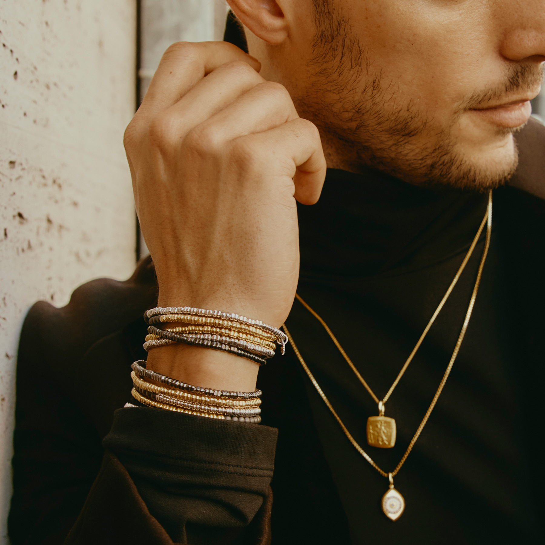 A bracelet with a combination of silver and grey titanium beads, featuring a half moon shape and a Tateossian gear tag.