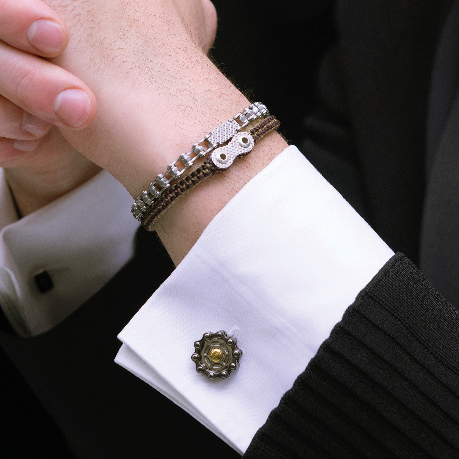Elegant industrial engineering inspired cufflinks with chain-link movement and contrasting gold centre detail.