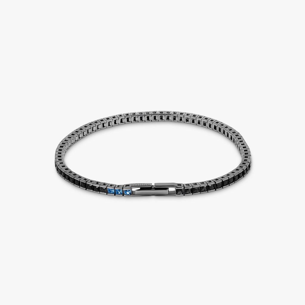 A black rhodium-plated sterling silver tennis bracelet with black nano stones and a blue stone accent on the clasp.