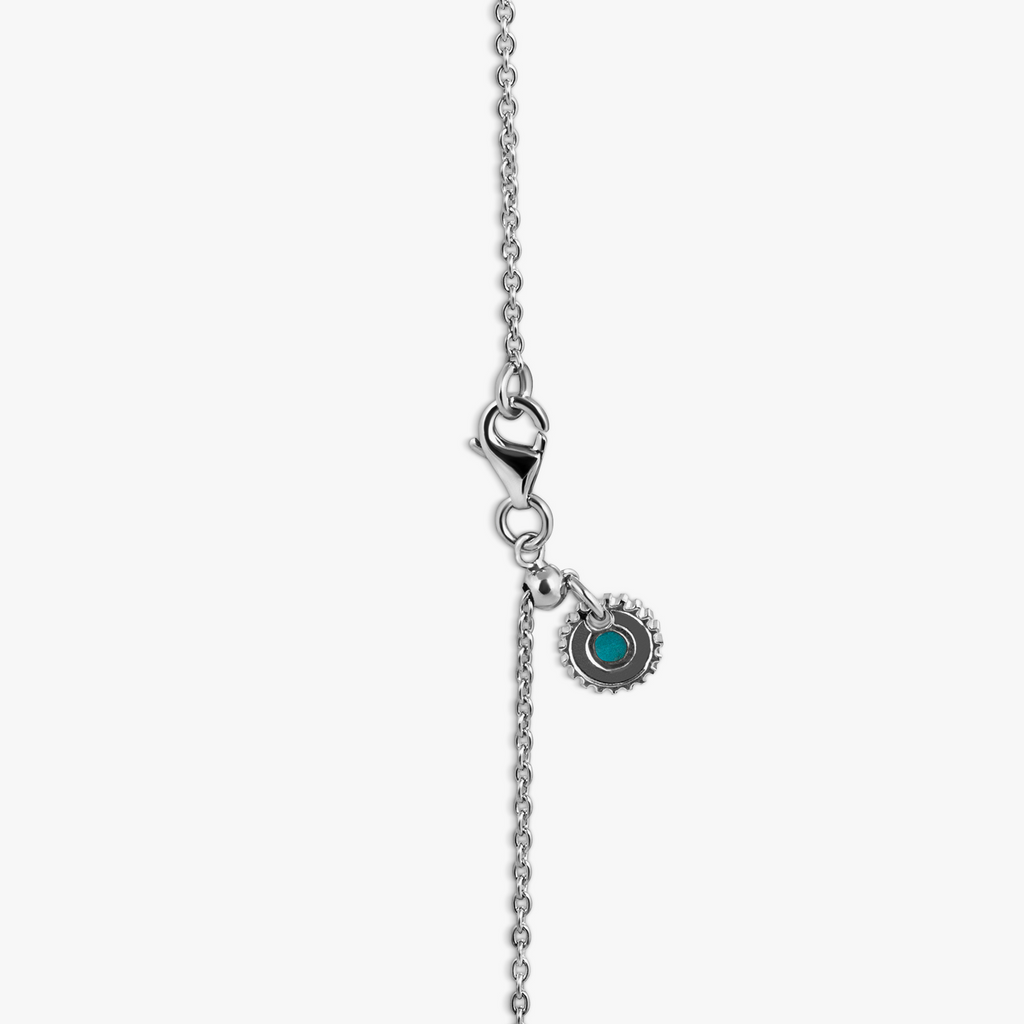 A rhodium-plated sterling silver necklace with a square-shaped pendant featuring a red garnet, set within a polished rounded square frame, with a chain visible in the background.