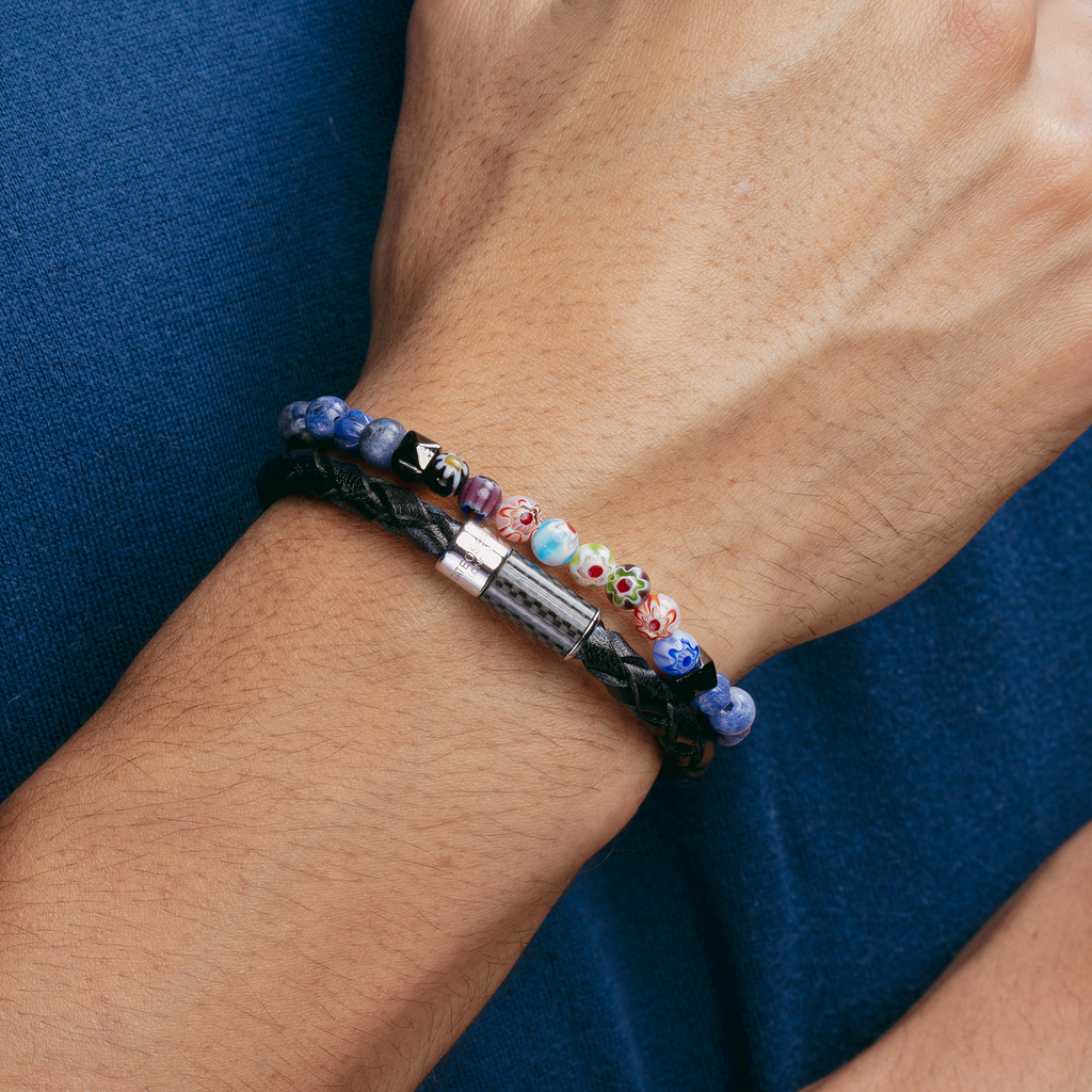A multicolored beaded bracelet with blue sodalite and millefiori design, strung on an elastic band.