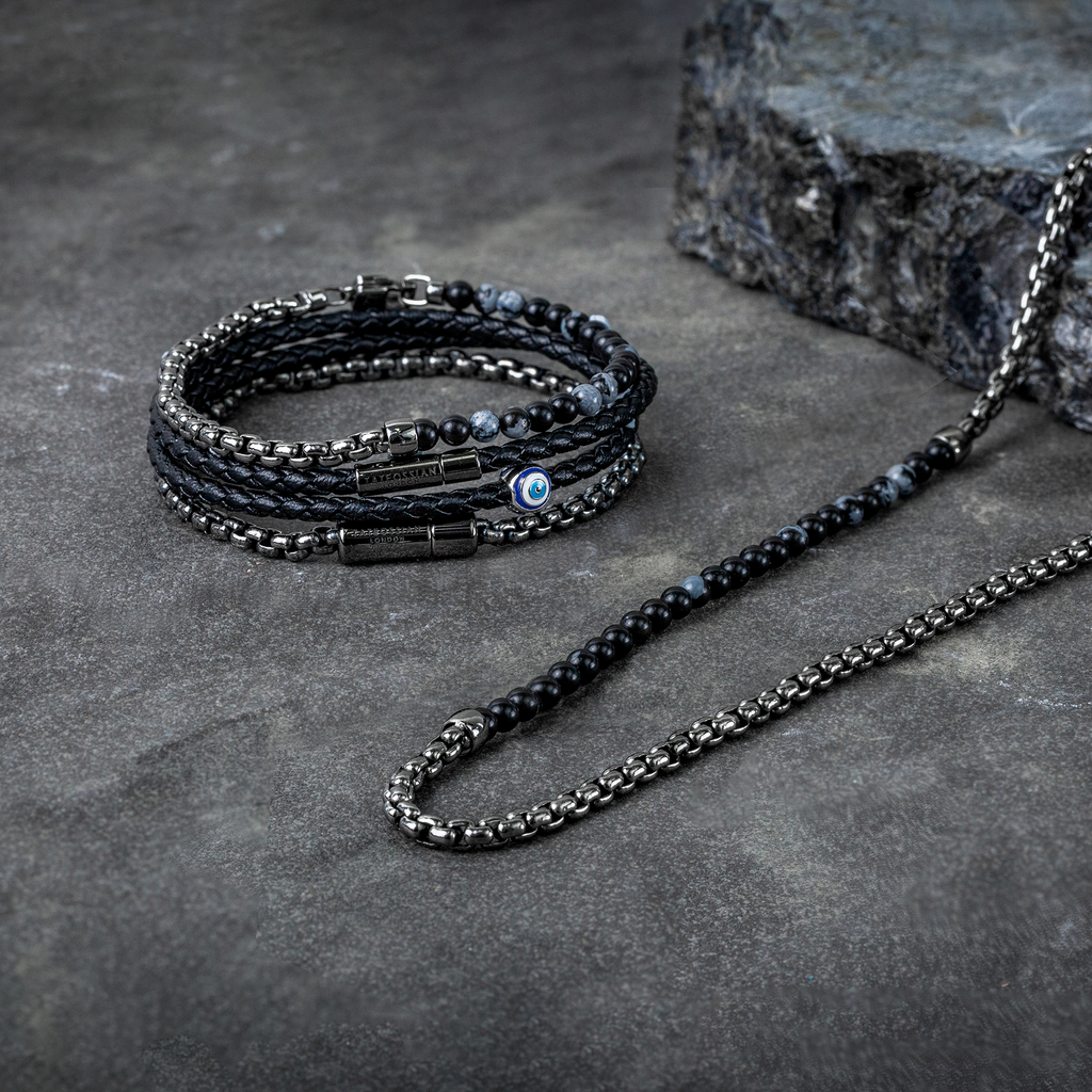 A black eco-friendly leather bracelet with a ruthenium-plated silver evil eye charm and a metal pop-clasp.
