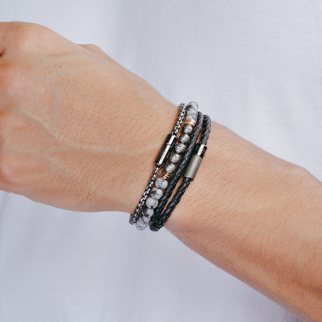 A black leather bracelet with a sterling silver clasp, double wrapped and intricately braided.