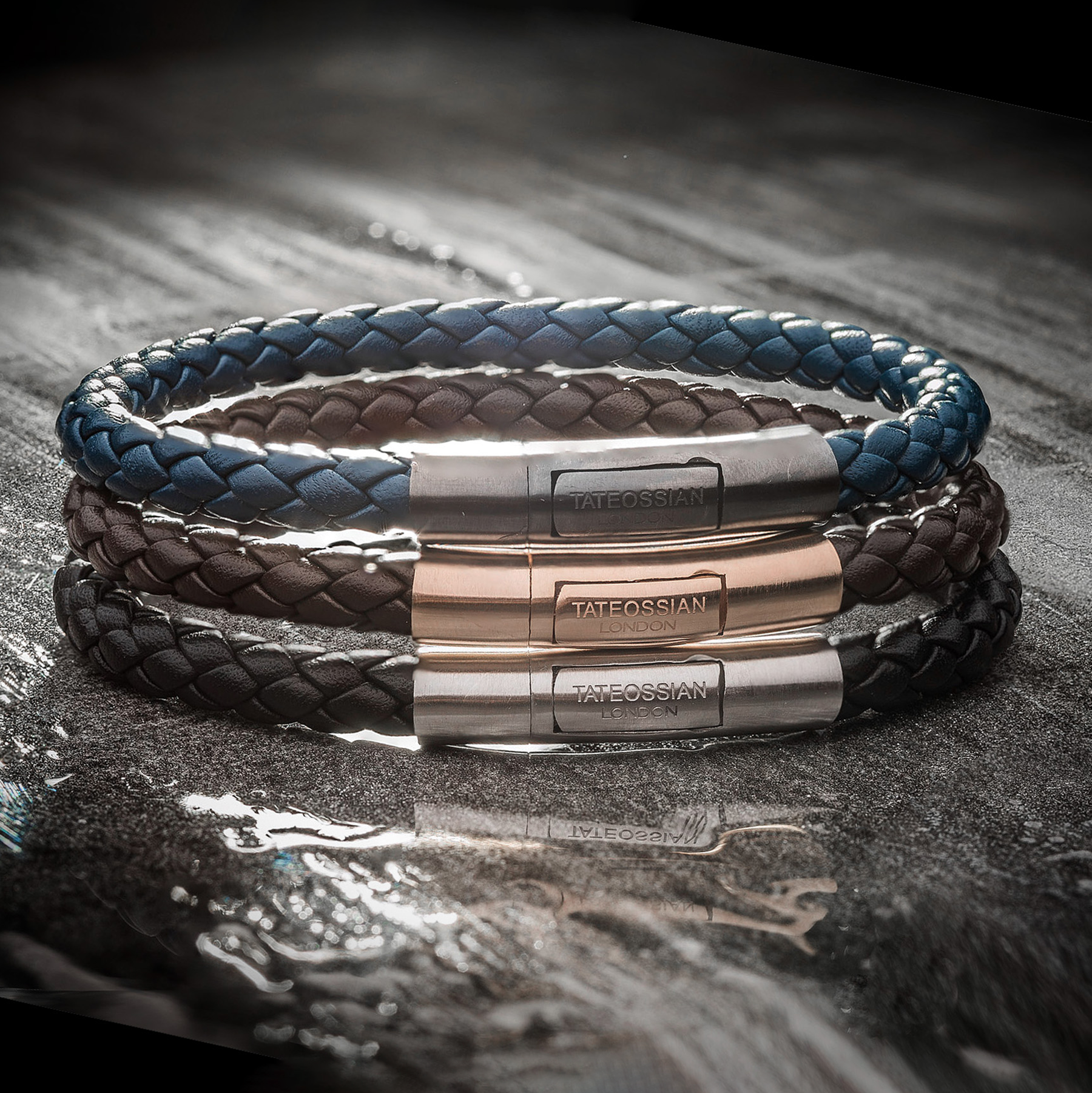 Charles Leather Bracelet In Navy braided Italian leather with polished sterling silver clasp on dark surface.