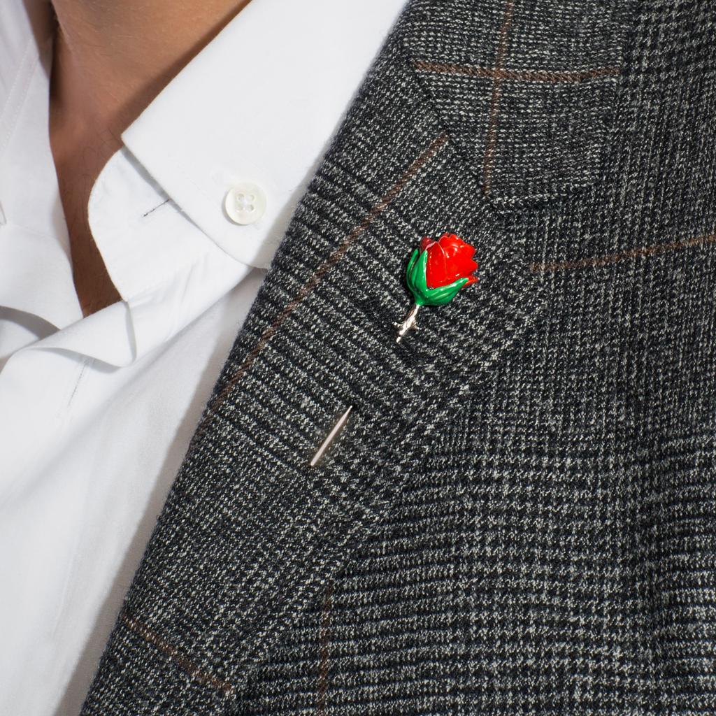A red rose lapel pin with a palladium plated metal stem and base. 