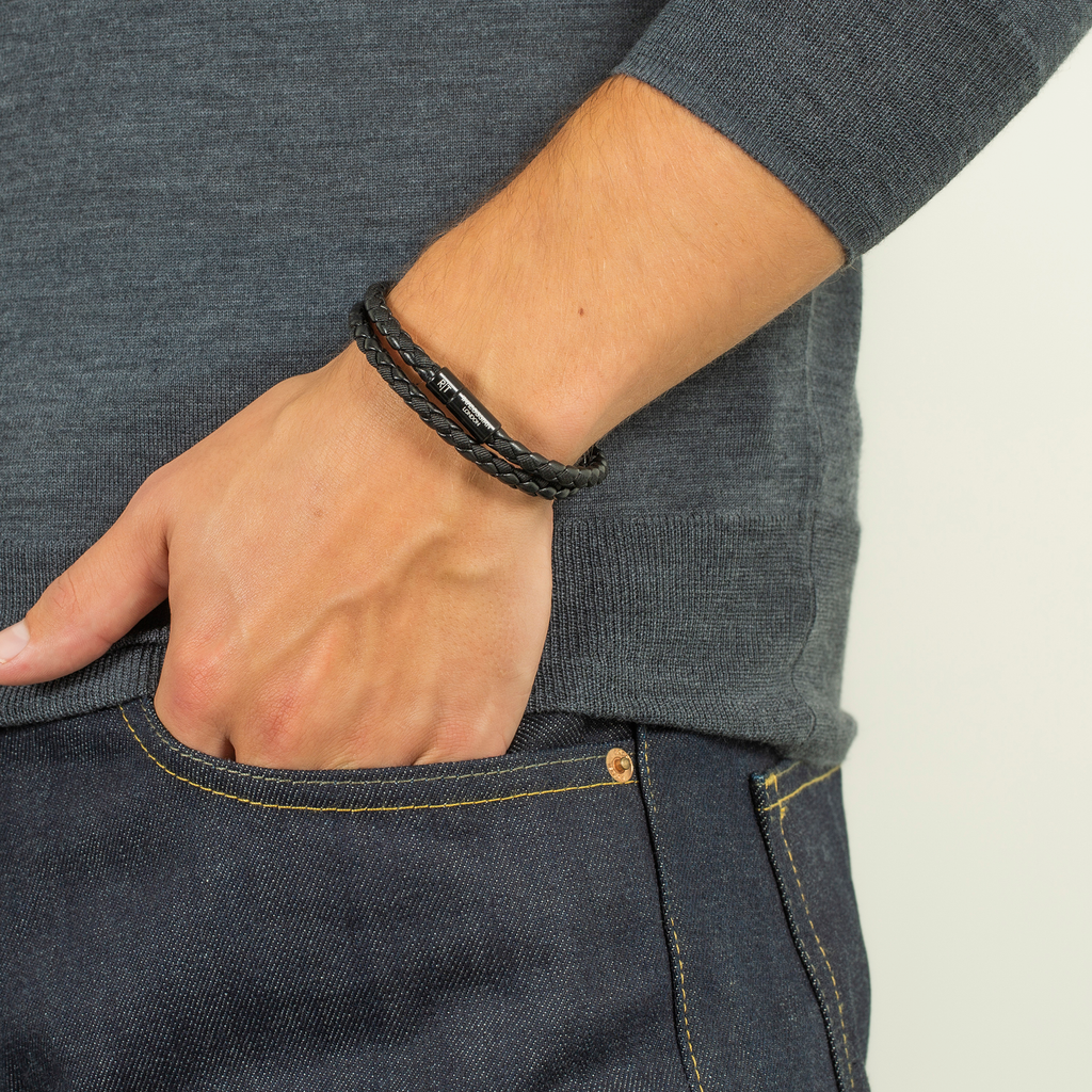 Close-up of a wrist wearing the Chelsea Leather Bracelet In Black With Aluminium Clasp with black braided fabric and leather.