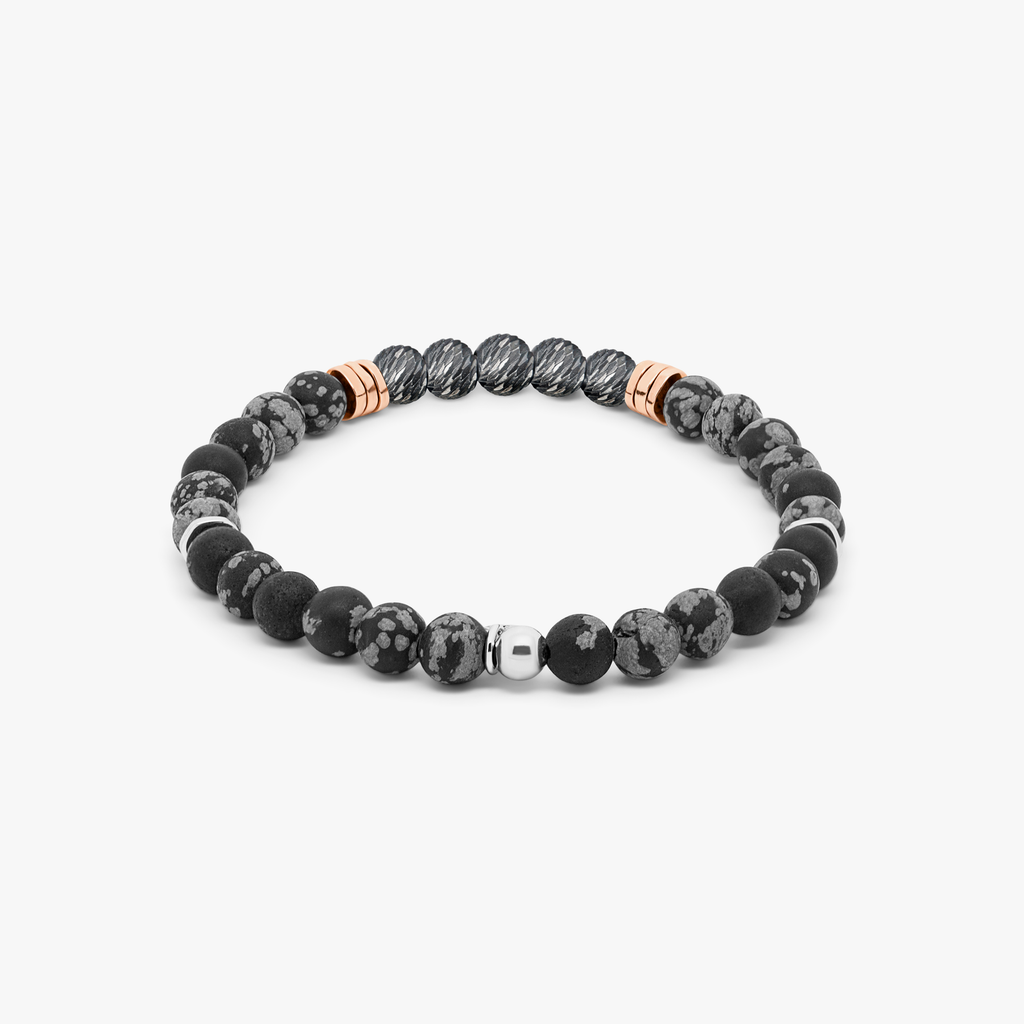 A black beaded bracelet with silver and rose gold-plated accents, featuring a snowflake obsidian stone and a small circular silver charm