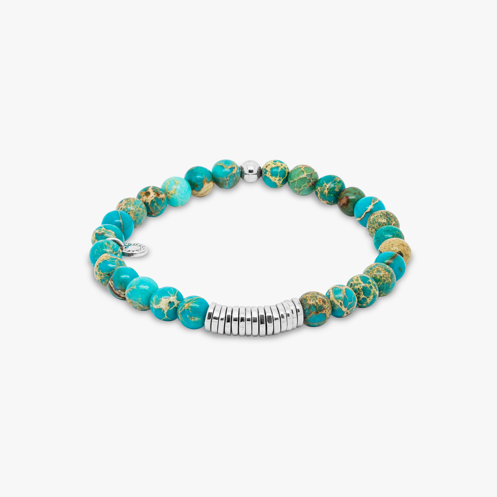 A bracelet with blue Impression Jasper beads and silver-colored discs, presented against a white background.
