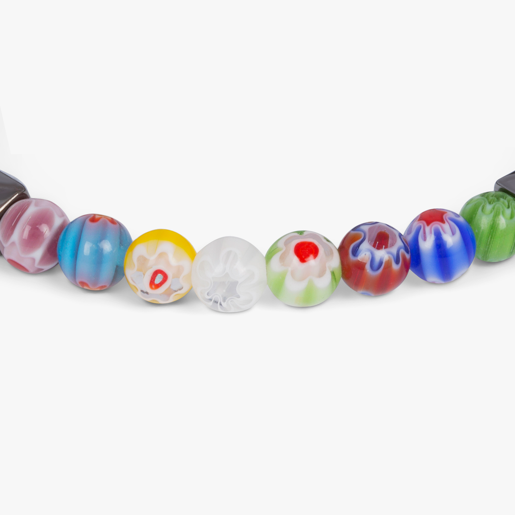 A beaded bracelet with black onyx stones and multicolored beads, showcasing a Millefiori pattern.
