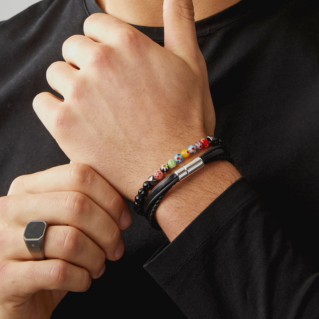 A beaded bracelet with black onyx stones and multicolored beads, showcasing a Millefiori pattern.