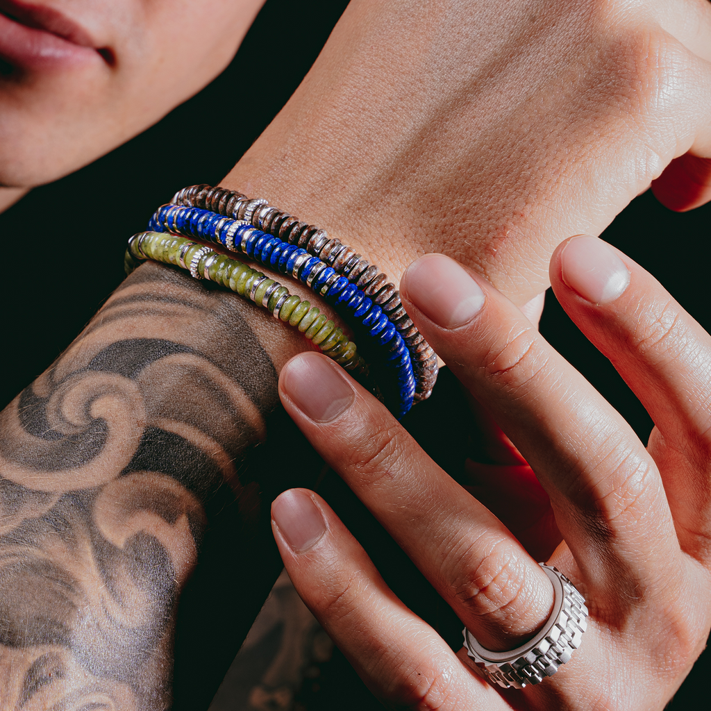 A blue beaded bracelet with rhodium plated sterling silver, featuring rondelle shaped blue lapis lazuli beads and gear discs.