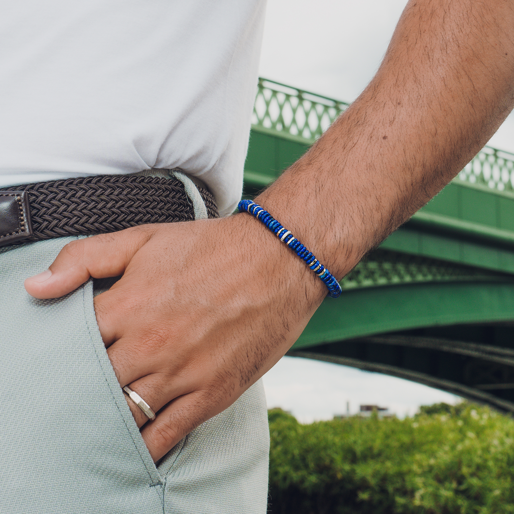 A blue beaded bracelet with rhodium plated sterling silver, featuring rondelle shaped blue lapis lazuli beads and gear discs.