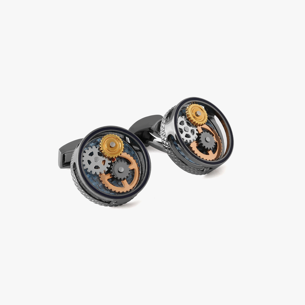 A pair of round gear cufflinks with a gunmetal plated finish and visible mechanical gears within.
